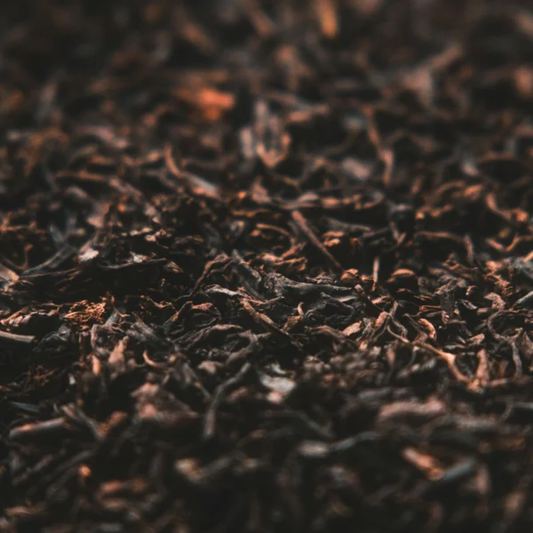 Close-up of dry black tea leaves with copper highlights